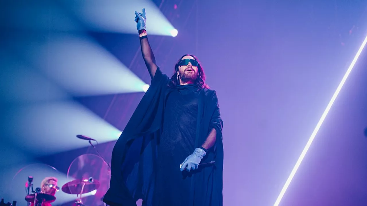 Jared Leto takes to the stage in quirky cape and shades with band Thirty Seconds to Mars in...