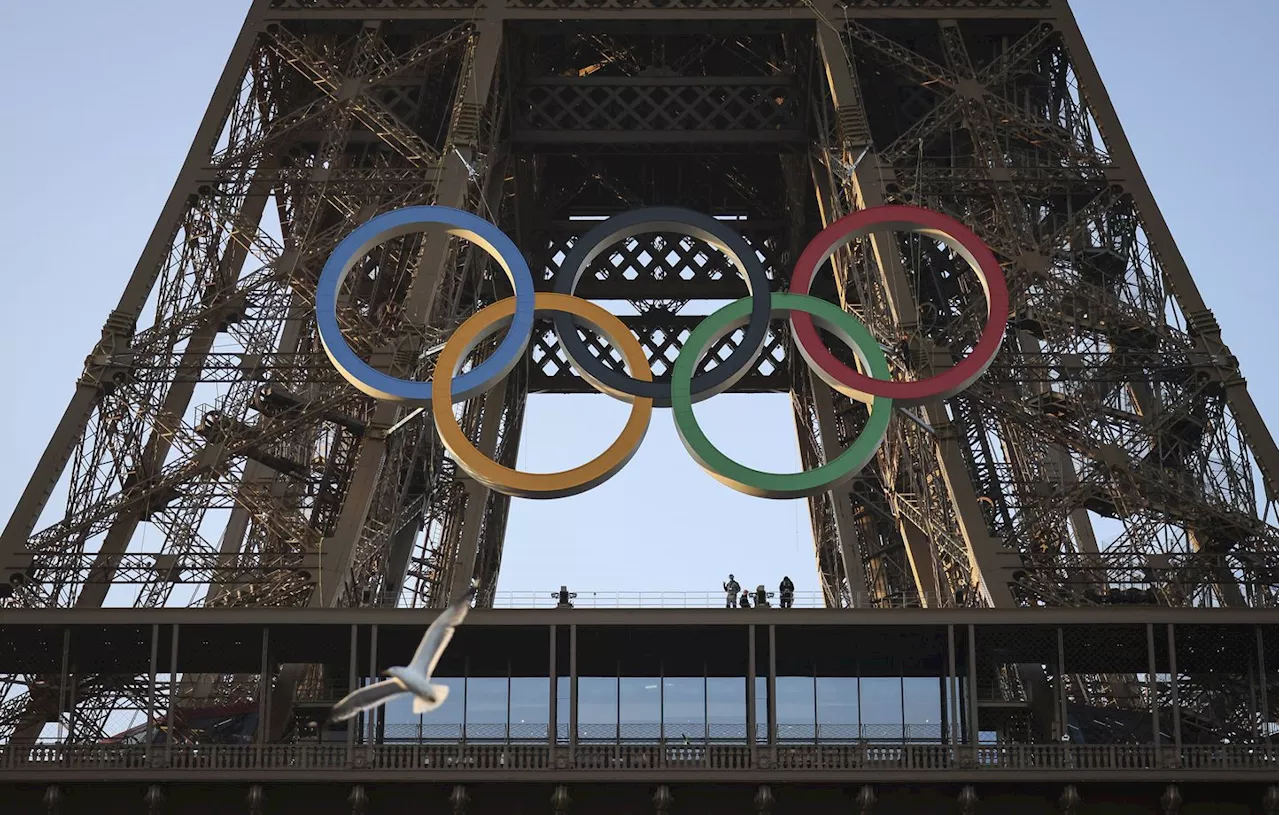 JO de Paris 2024 : Les cinq anneaux olympiques accrochés sur la Tour Eiffel