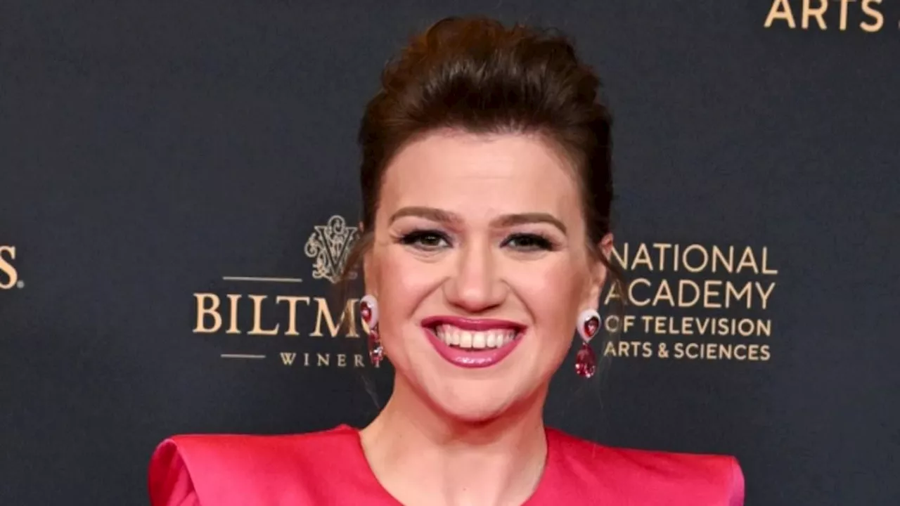 Kelly Clarkson proudly shows off her slimmed-down figure in a fitted pink gown with stylish Zooey...