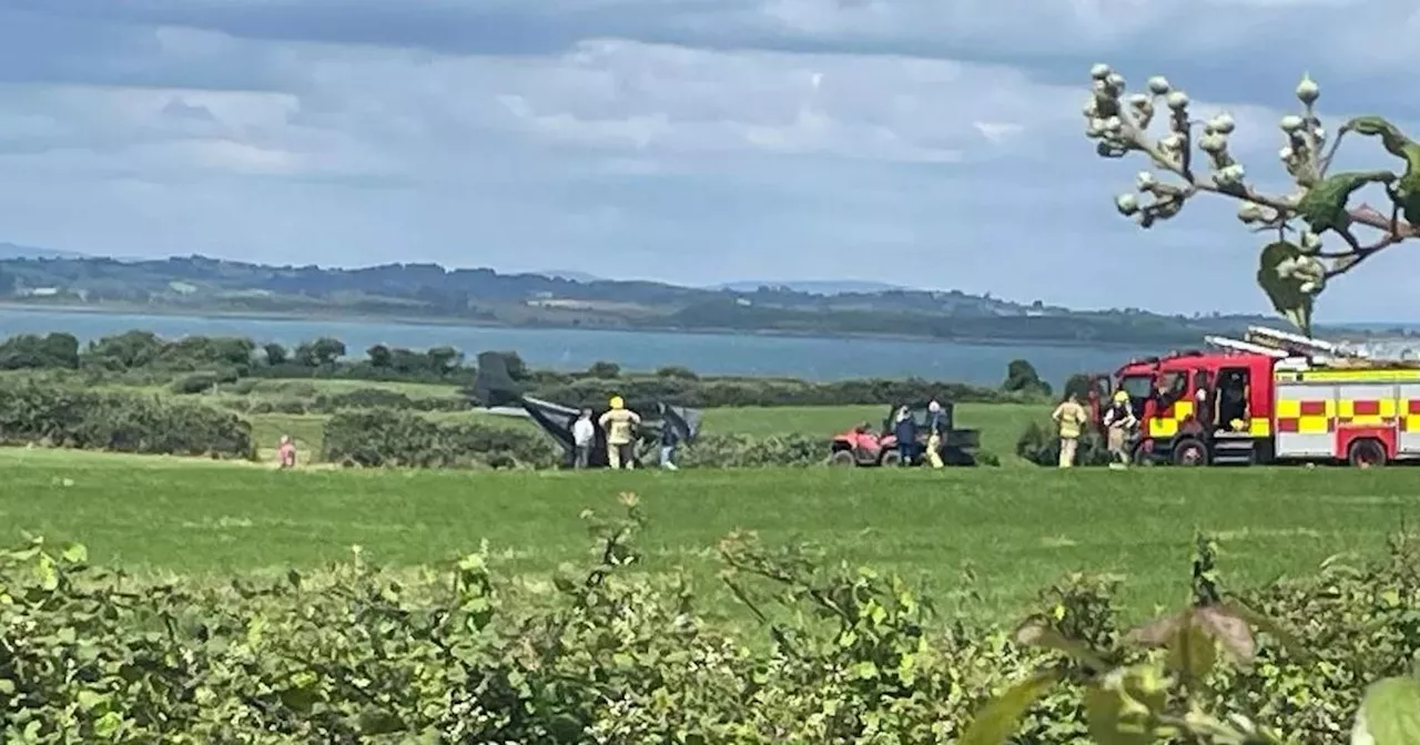 Emergency services at scene after aircraft makes emergency landing in field