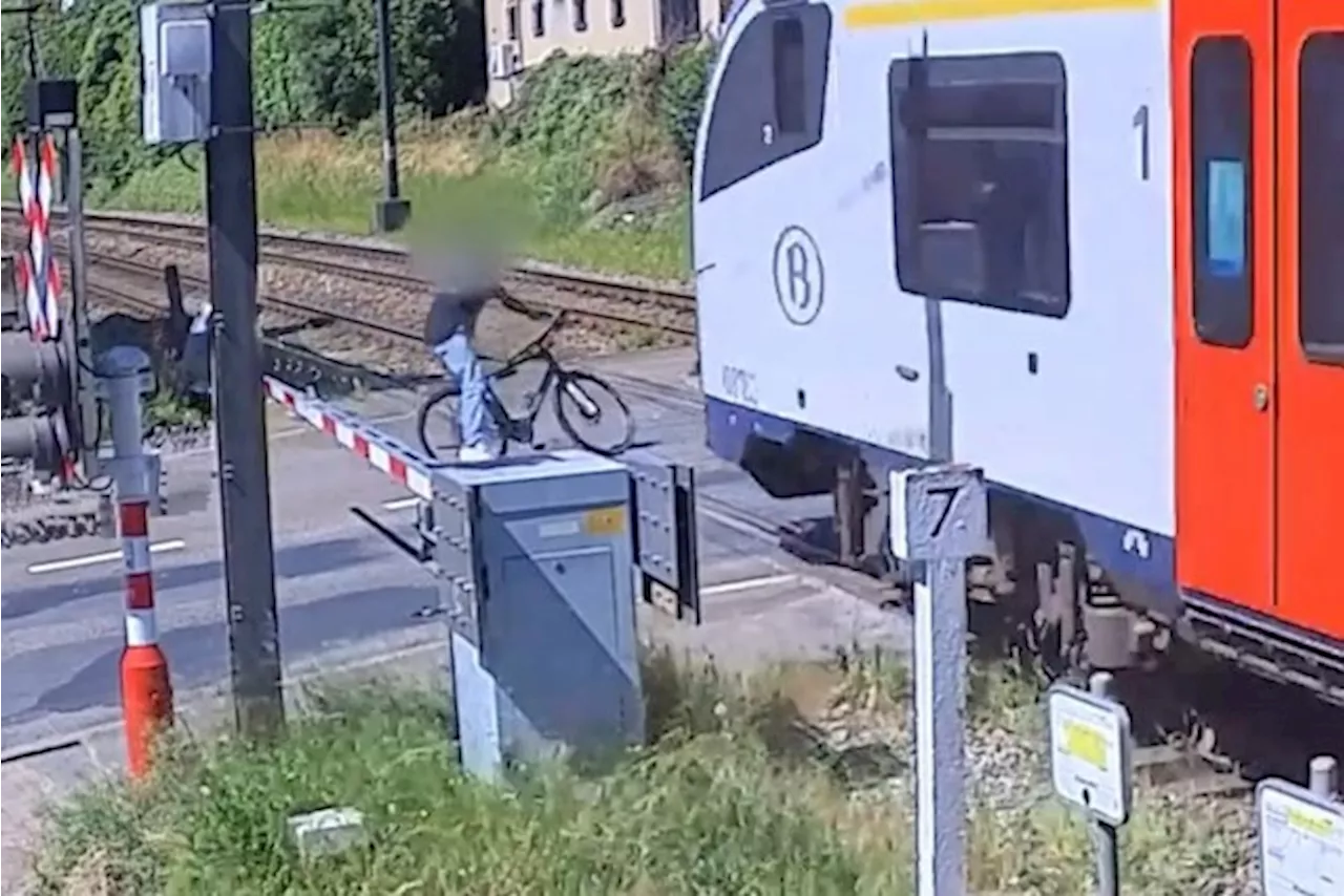 Hallucinante beelden tonen hoe fietser die slagbomen negeert op haar na ontsnapt aan trein, die wel zijn fiets