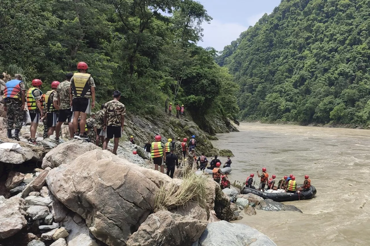 Rescuers recover first body from 2 buses that were hit by landslide and fell into a river in Nepal