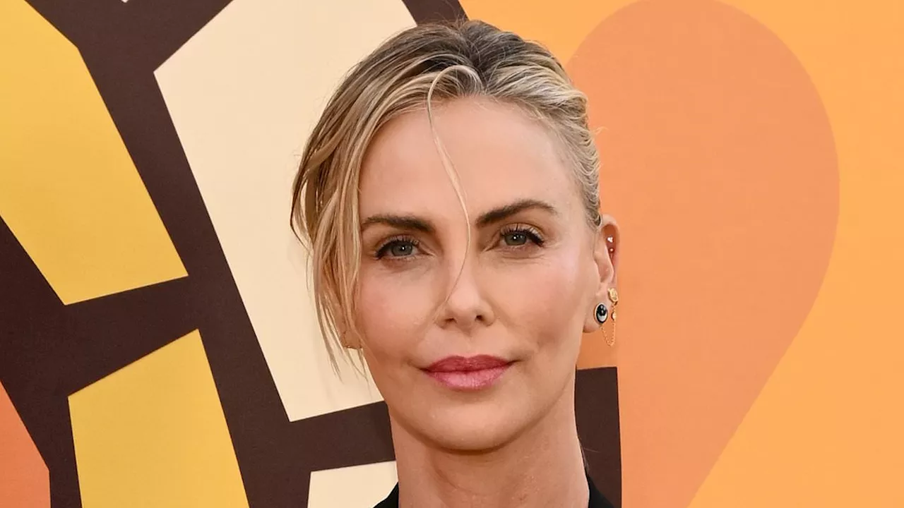 Charlize Theron showcases her incredible figure in a skimpy bralette top and shimmering skirt as she...