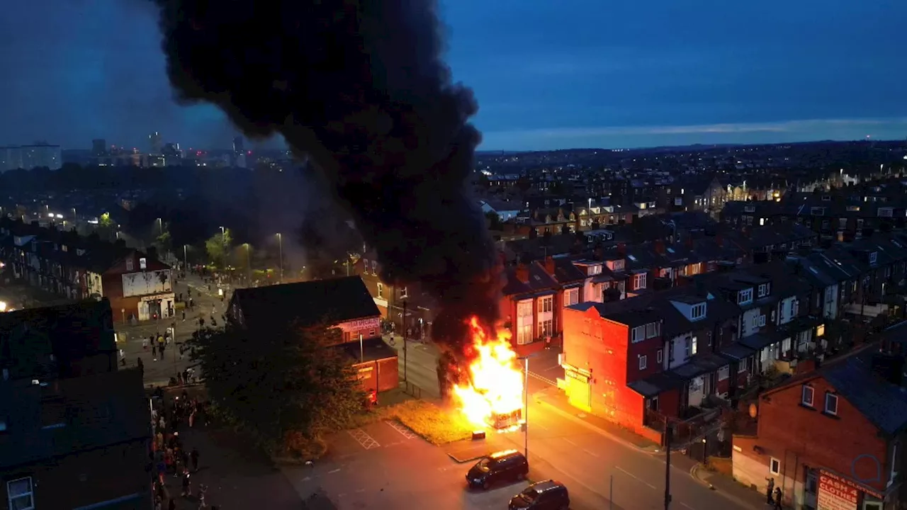 Bus set on fire and police car flipped over as riot breaks out in Leeds with hundreds out on streets