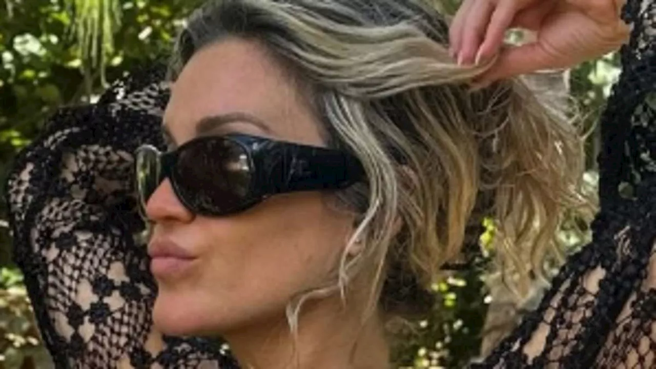 Ashley Roberts sends temperatures soaring as she flaunts her figure in a skimpy black bikini during...