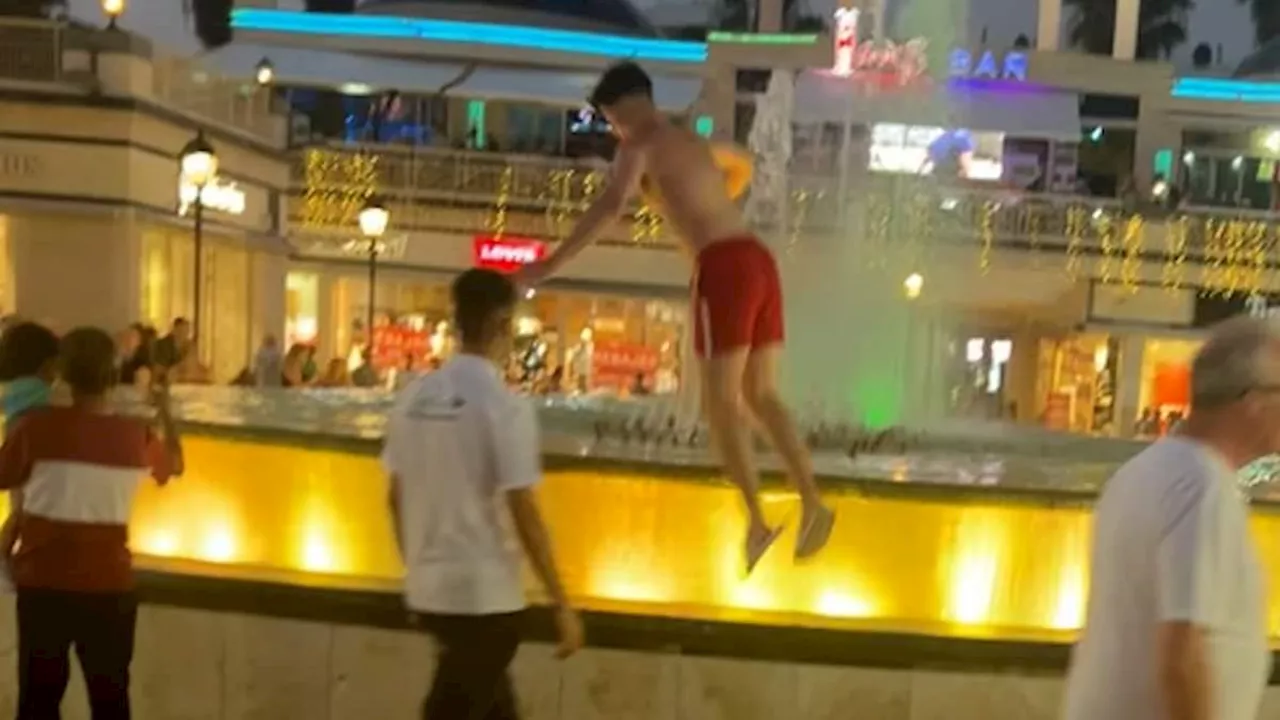 Moment Brit tourist is dragged away after jumping into Tenerife fountain for £20 bet