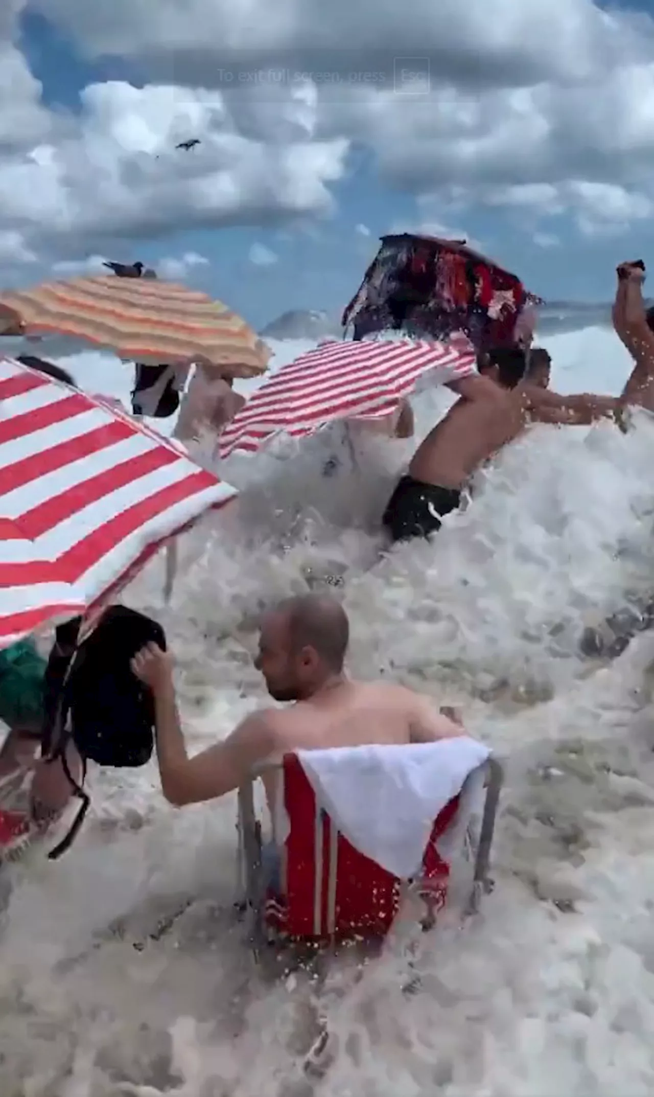 Watch moment freak 11ft high wave smashes into tourist beach washing away sunbathers, loungers & umbrellas...