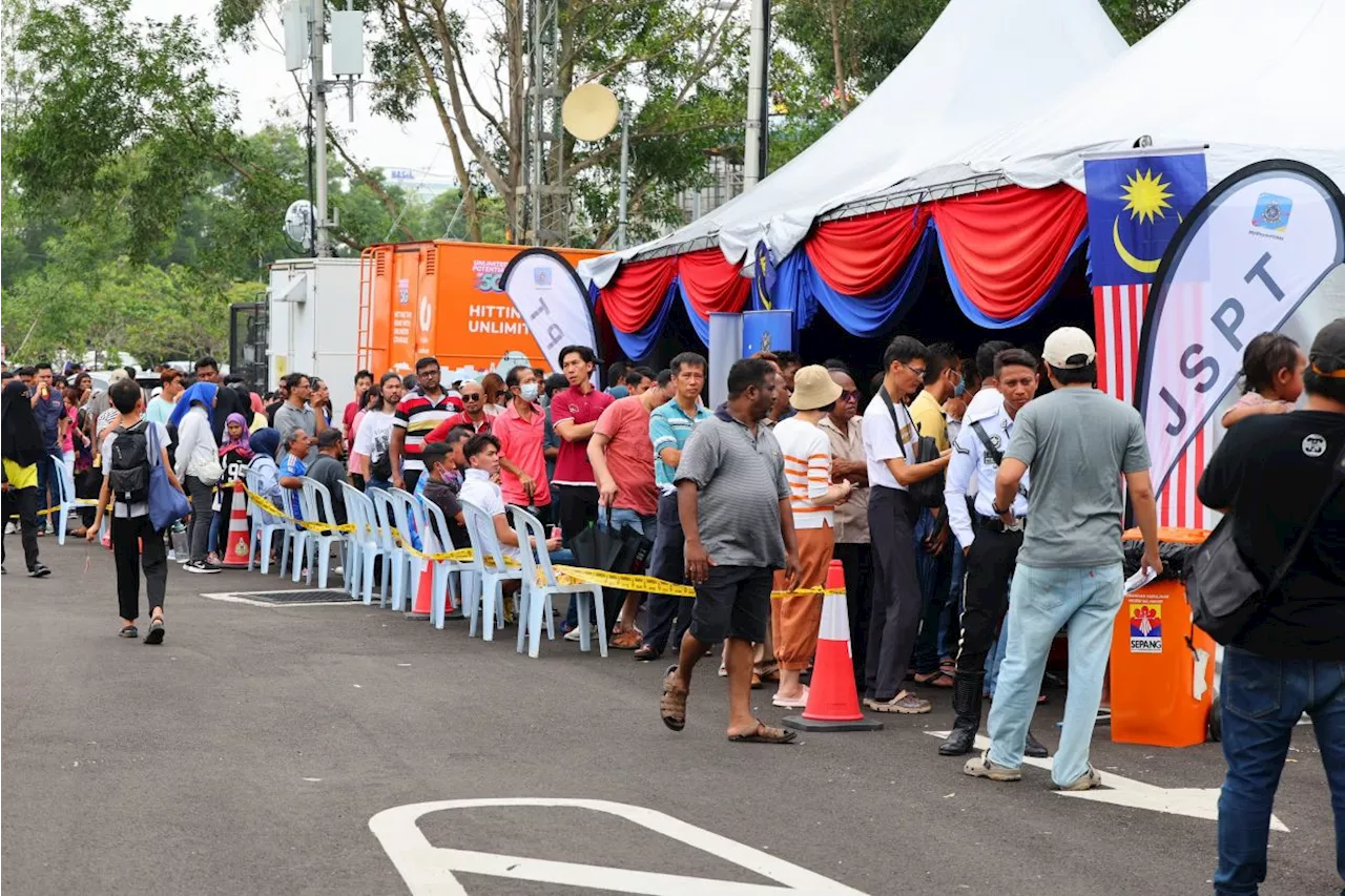 Hundreds crowd police booth to settle discounted traffic summonses at National Month launch