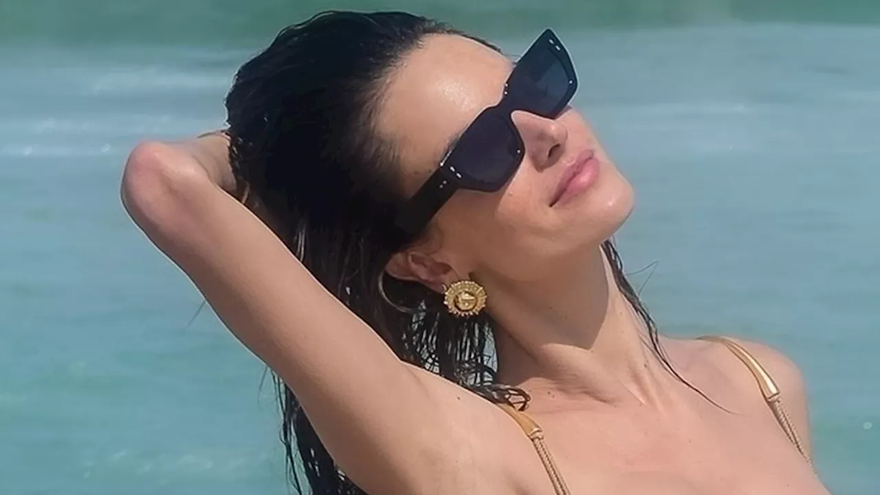 Alessandra Ambrosio, 43, shows off her phenomenal physique in skimpy black string bikini while...