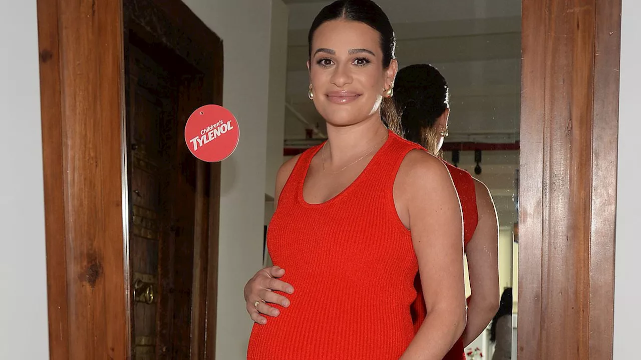 Lea Michele looks heavily pregnant as she displays her growing baby bump in a form-fitting red dress...