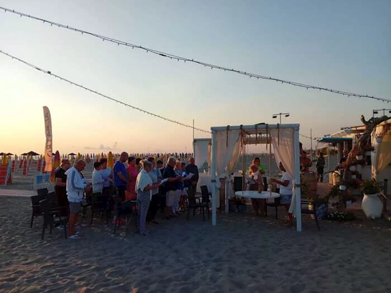 In Puglia un sacerdote benedice i nonni all'alba in spiaggia