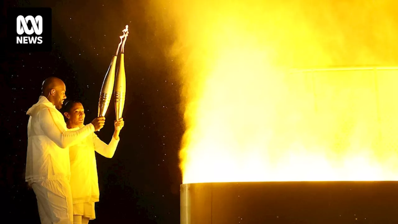 Who carried and who lit the flame during the 2024 Paris Olympics opening ceremony?