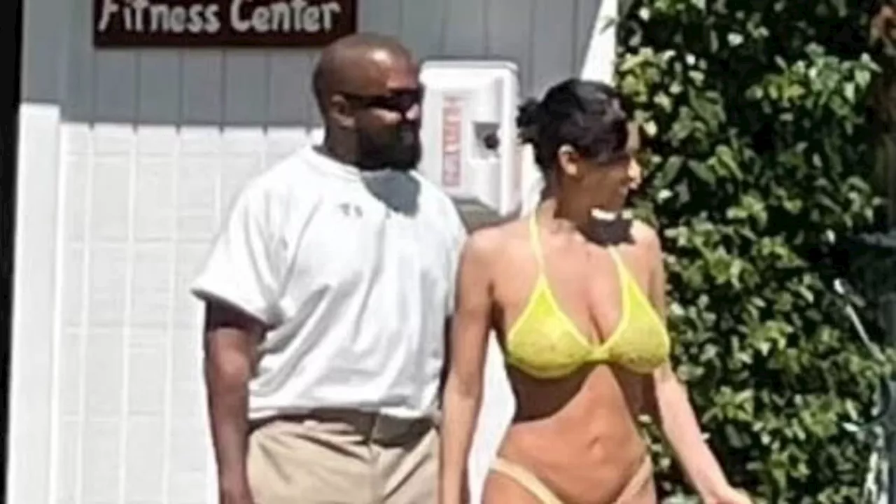 Kanye West's wife Bianca Censori rocks a busty yellow bikini while he goes fully clothed at the pool...