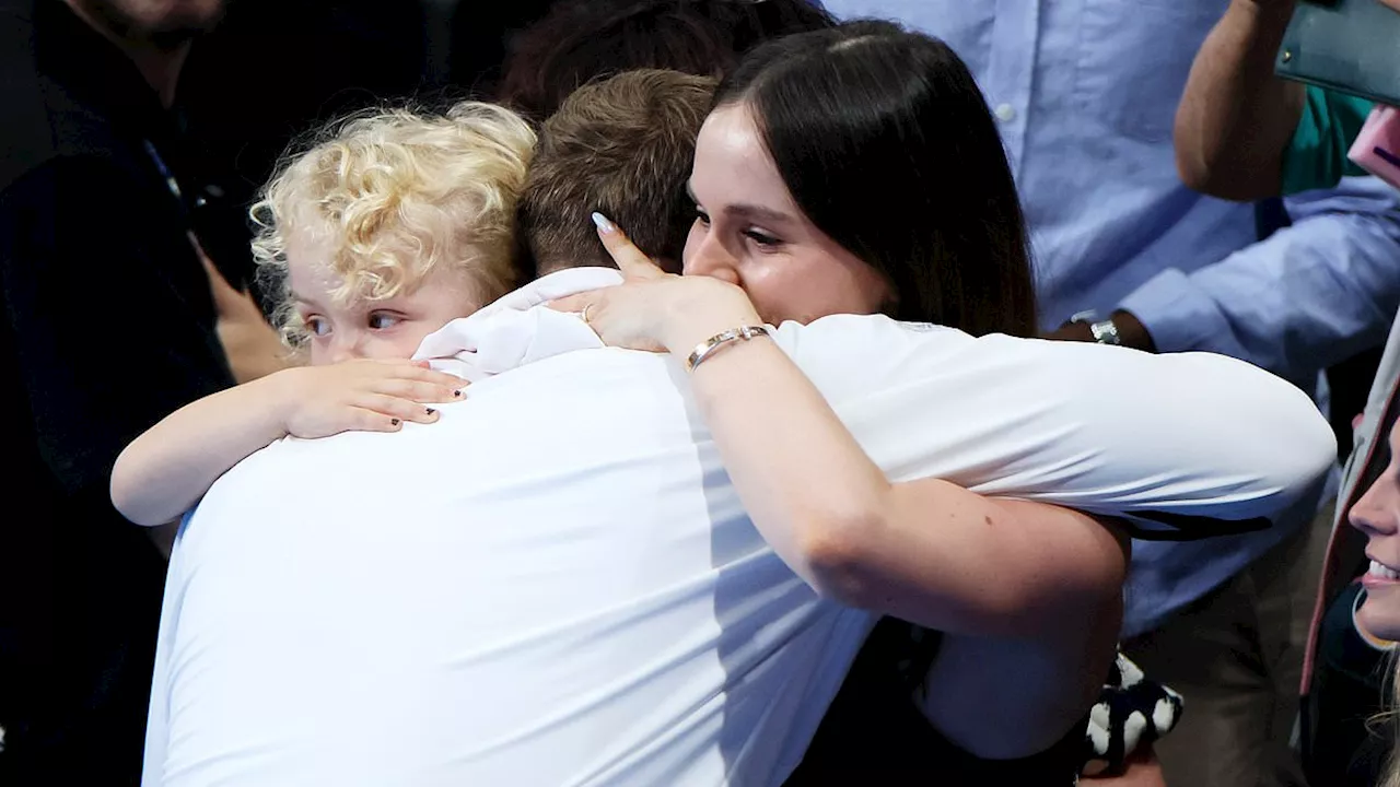 Adam Peaty's girlfriend Holly Ramsay congratulates the tearful Olympic swimmer with a kiss after she...