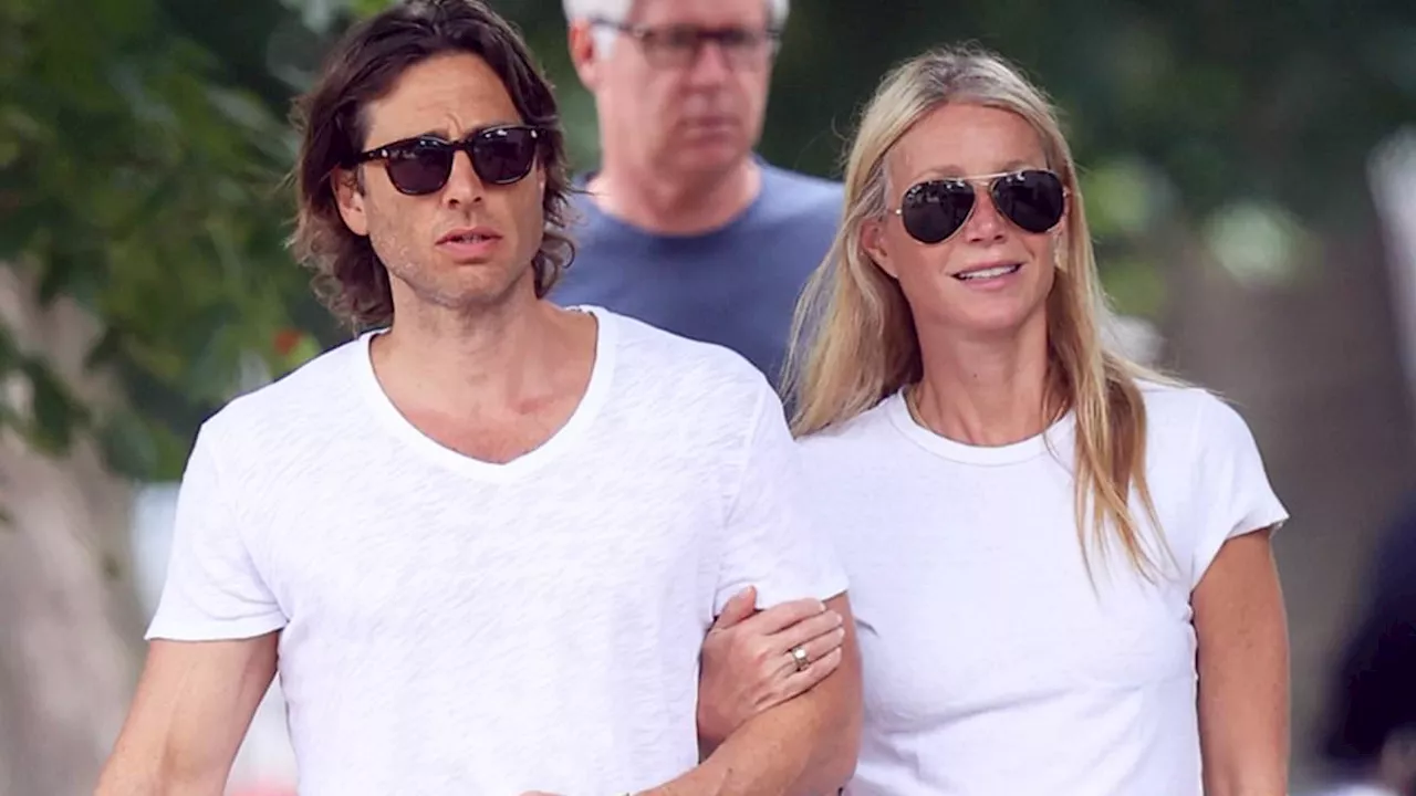 Gwyneth Paltrow, 51, looks youthful in a white shirt as she holds onto husband Brad Falchuk in the...