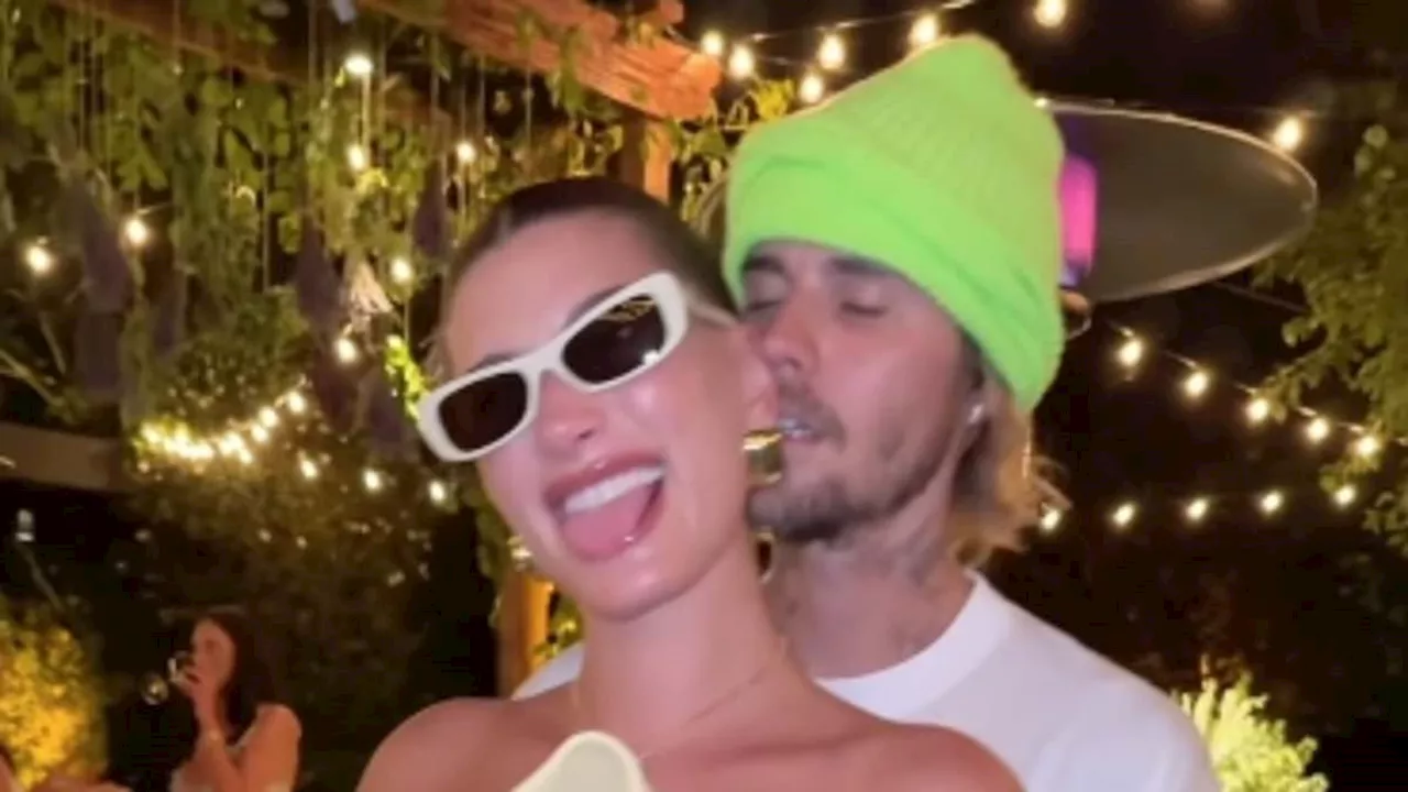 Hailey Bieber caresses her growing baby bump with husband Justin in sweet social media video as...