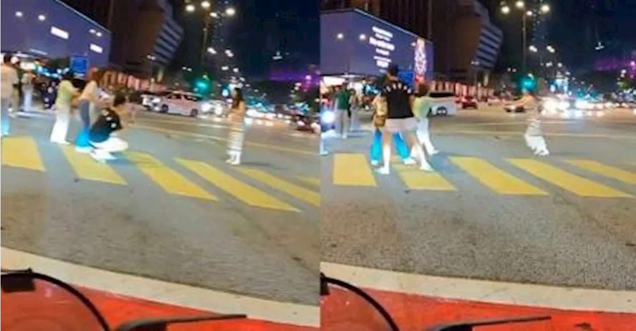 Selfish tourist poses in the middle of KL road for photo.