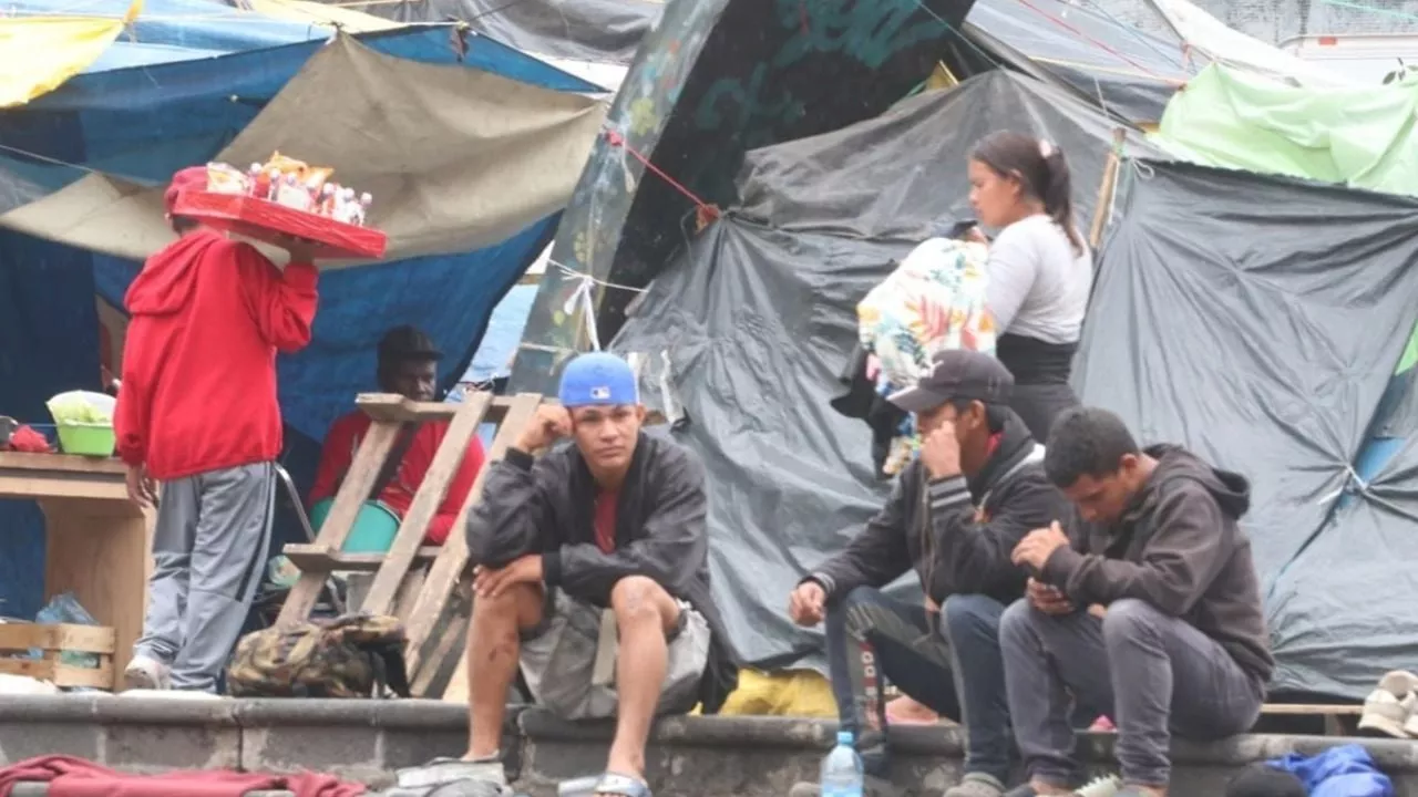 Migrantes en la Merced: Bajo la lluvia esperan entrar a un albergue saturado