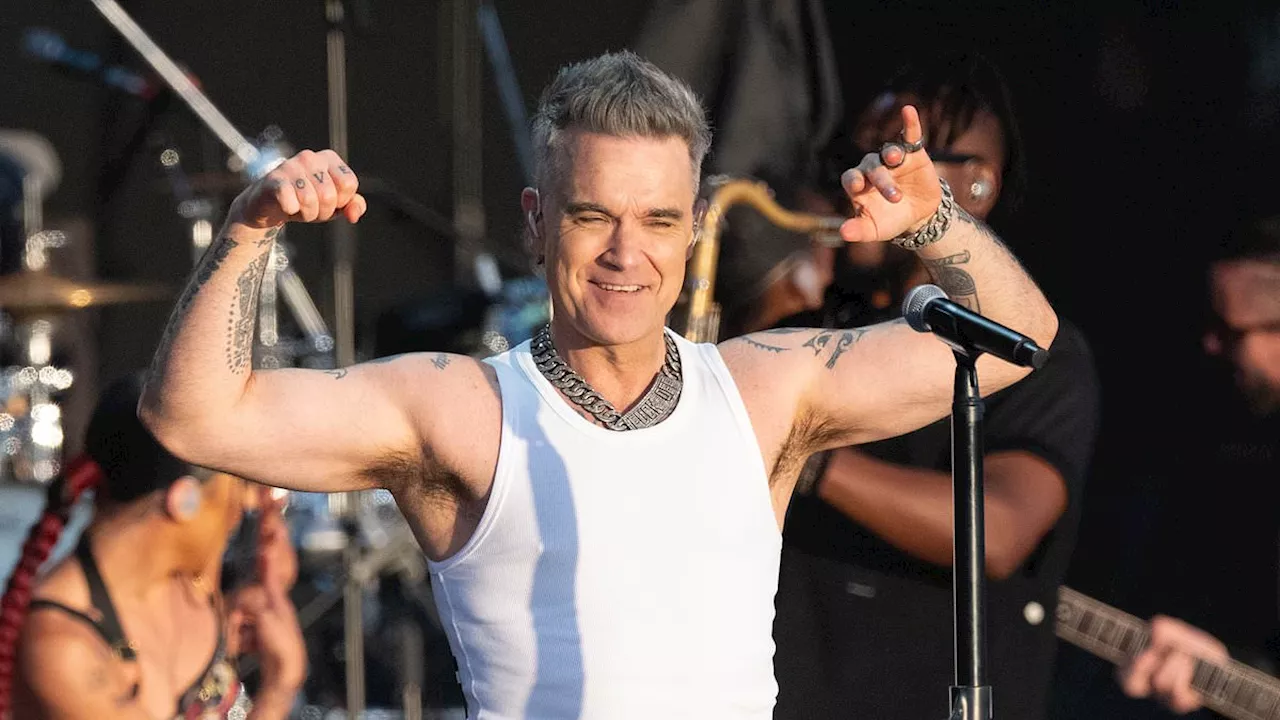 Robbie Williams' bottom is playfully grabbed by a dancer on stage during unforgettable BST Hyde Park...