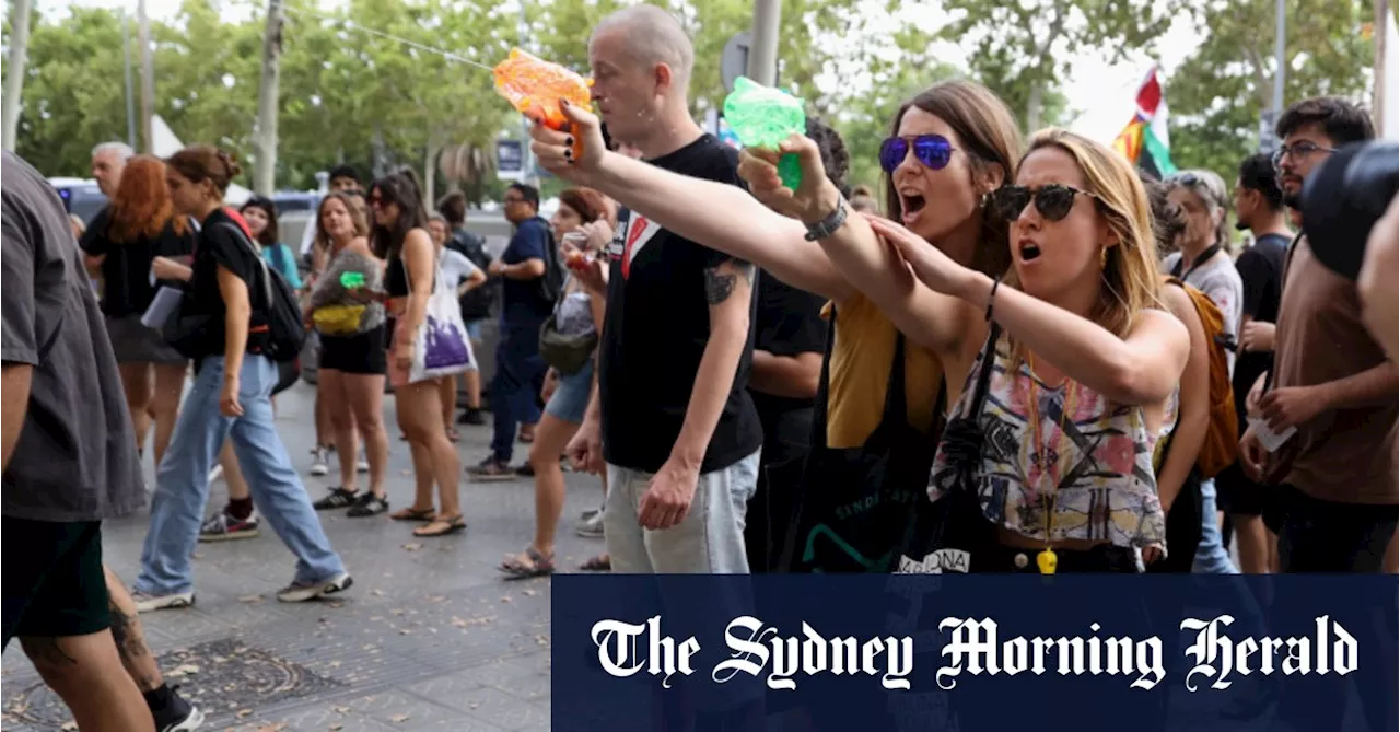 ‘Tourism kills the city’: Protesters soak diners with water pistols