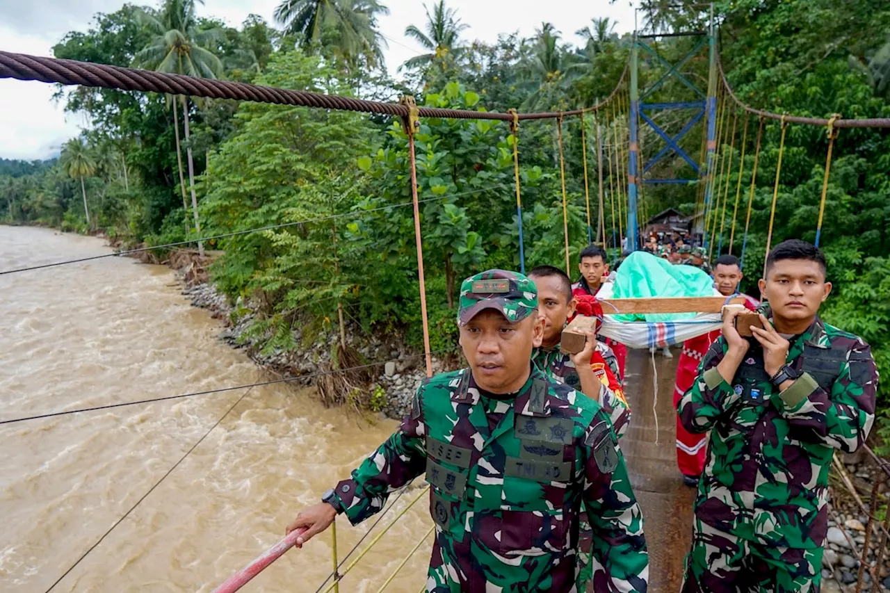 Rescuers search for dozens buried in an Indonesian landslide that killed at least 11 people