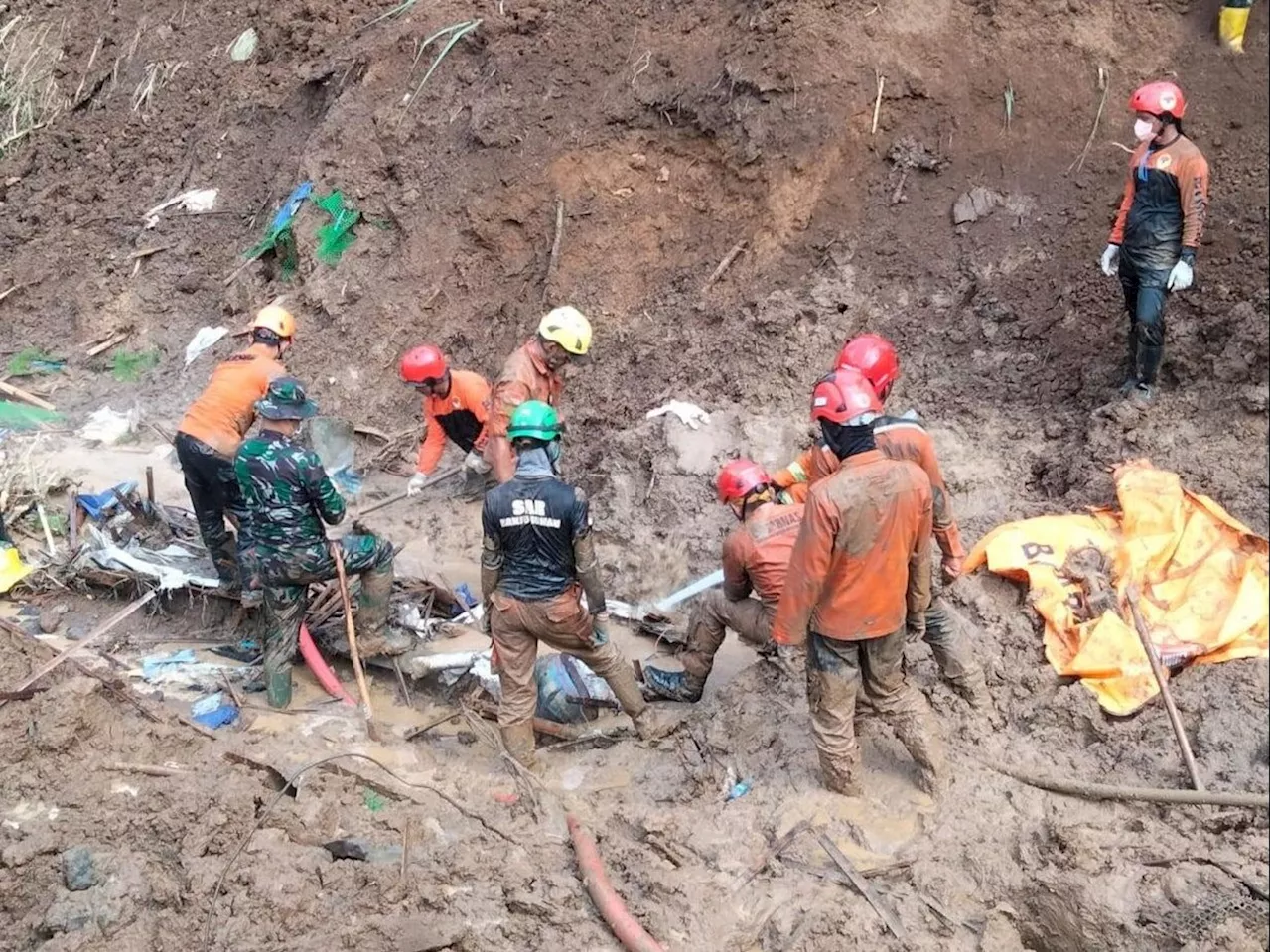 Rescuers in frantic search for dozens buried by an Indonesian landslide; death toll now rises to 23