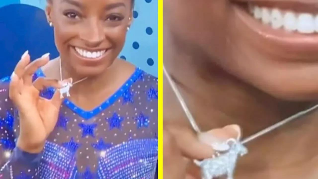 Simone Biles proudly shows off a silver GOAT necklace to let the world know who the greatest really is...