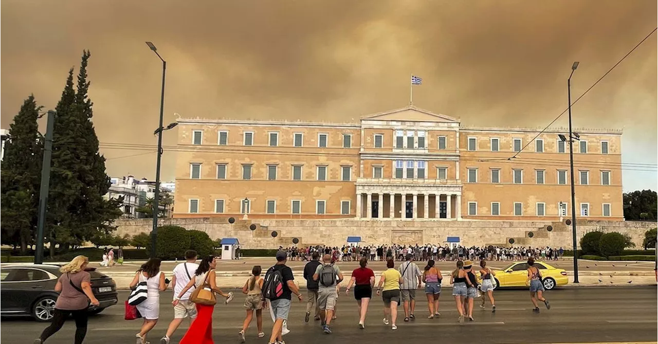 A wildfire near Greece's capital darkens the skies over Athens and advances fast