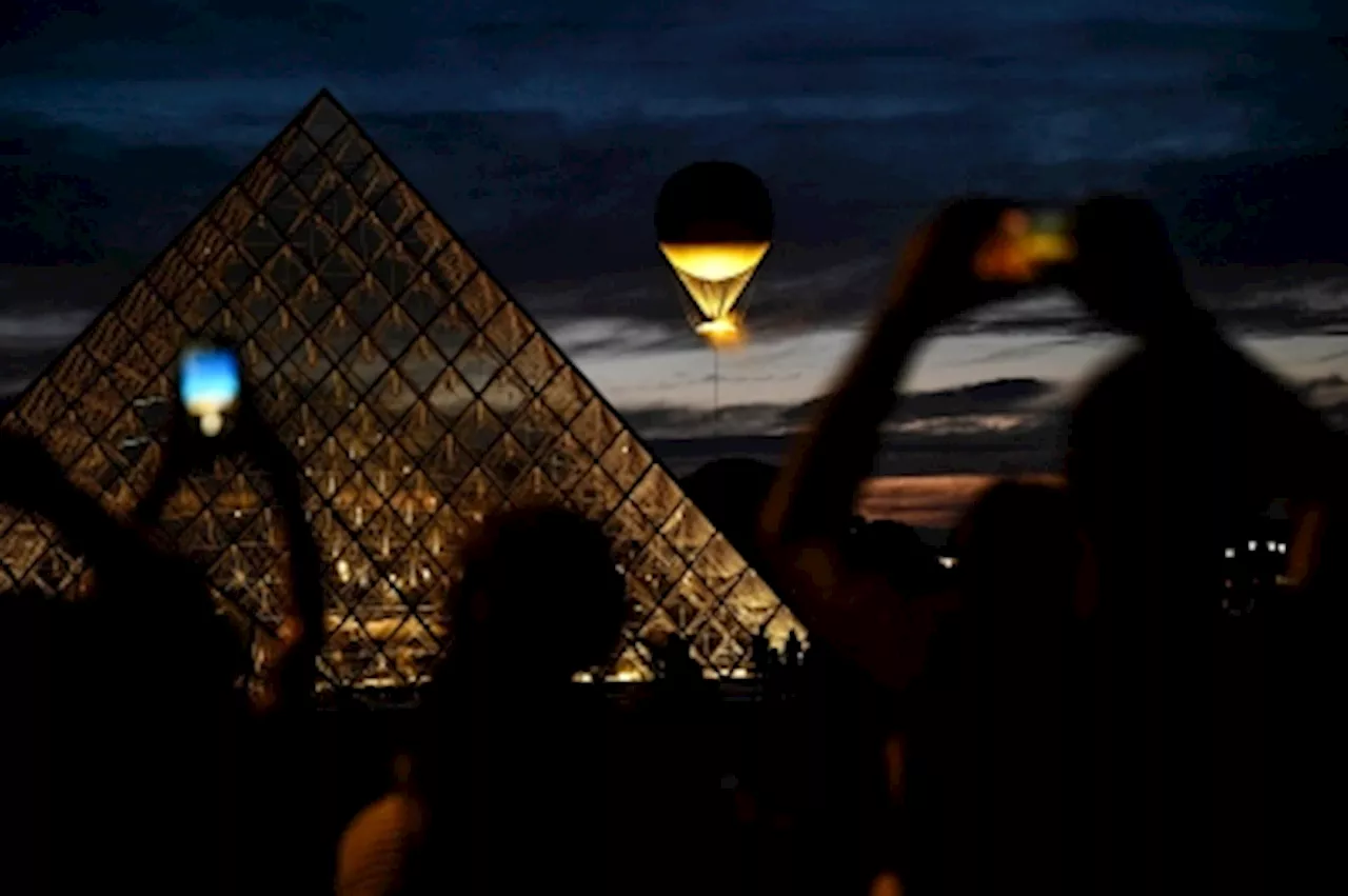 With thousands lining up for selfies daily, will the Olympic cauldron stay as part of Paris skyline?