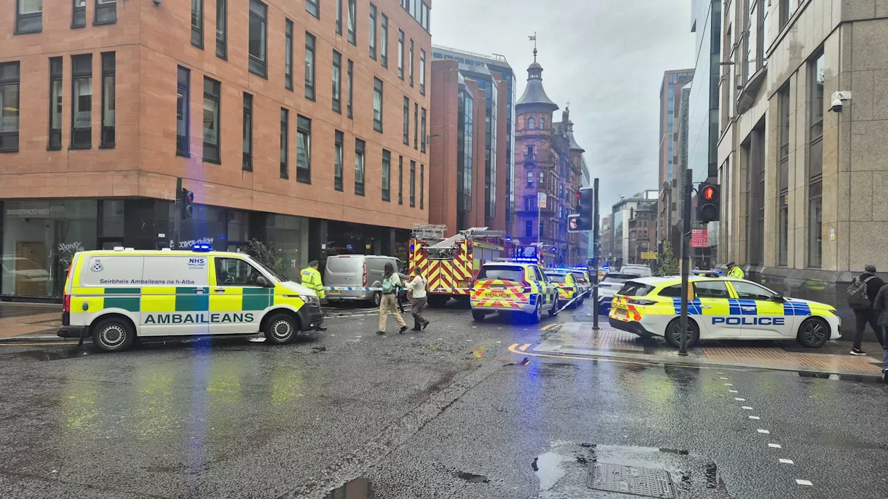 Police and ambulance crews focus on black car at bottom of Glasgow lane as streets sealed off amid...