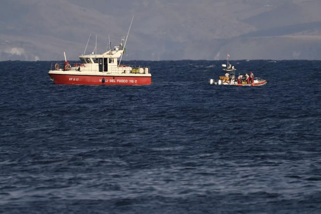 Rescue crews unload body bag in Sicily port as search continues after yacht sinking