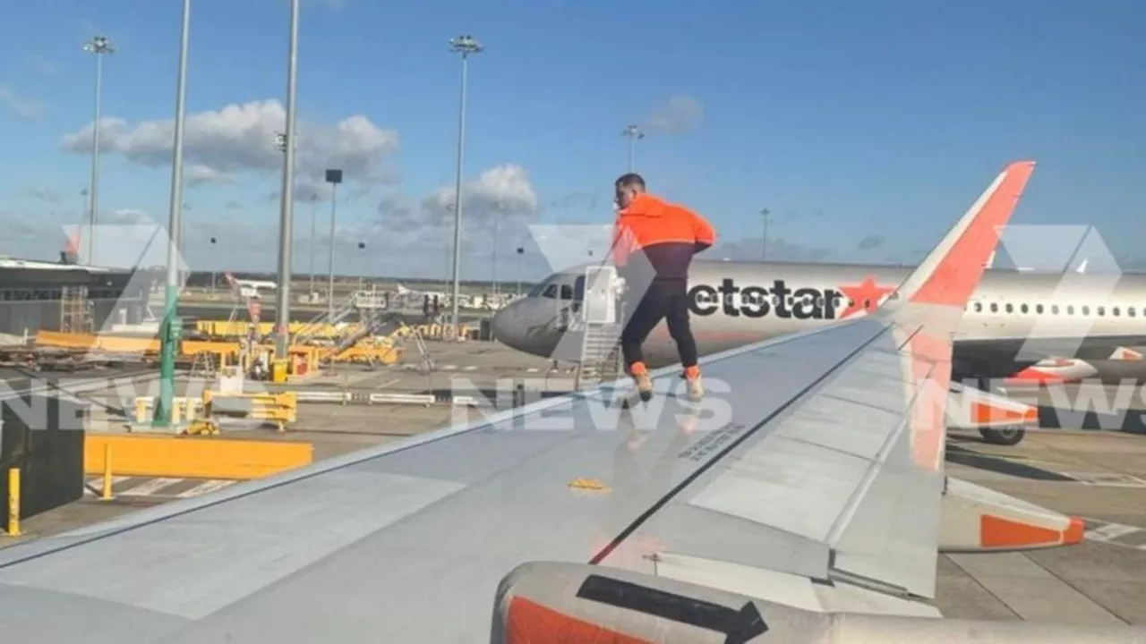 Man arrested after opening emergency exit door, climbing onto wing of Jetstar plane at Melbourne airport