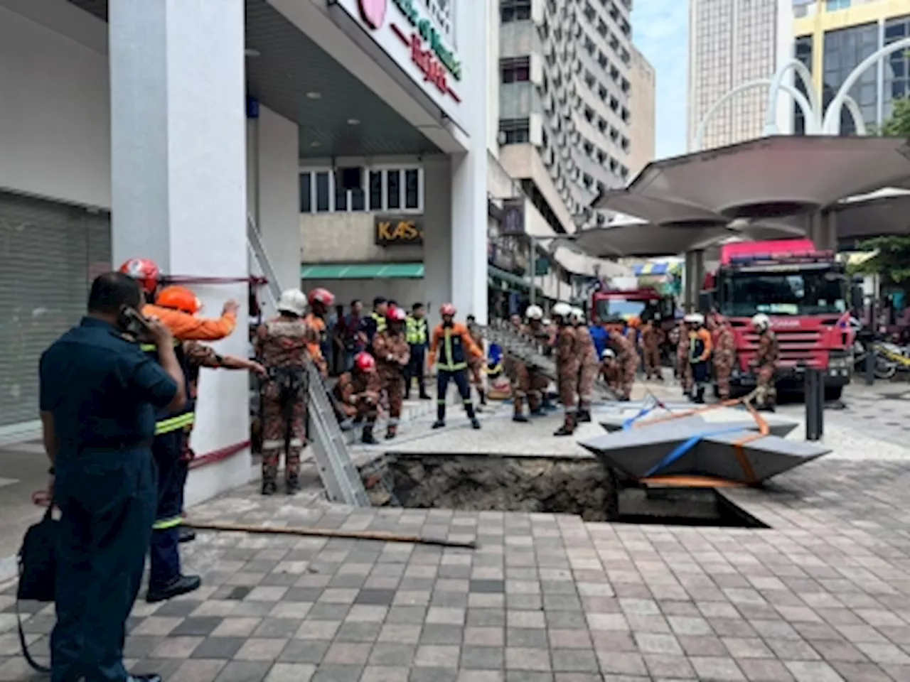 Sinkhole appears near Jalan Masjid India in KL, swallows woman; rescue underway (VIDEO)