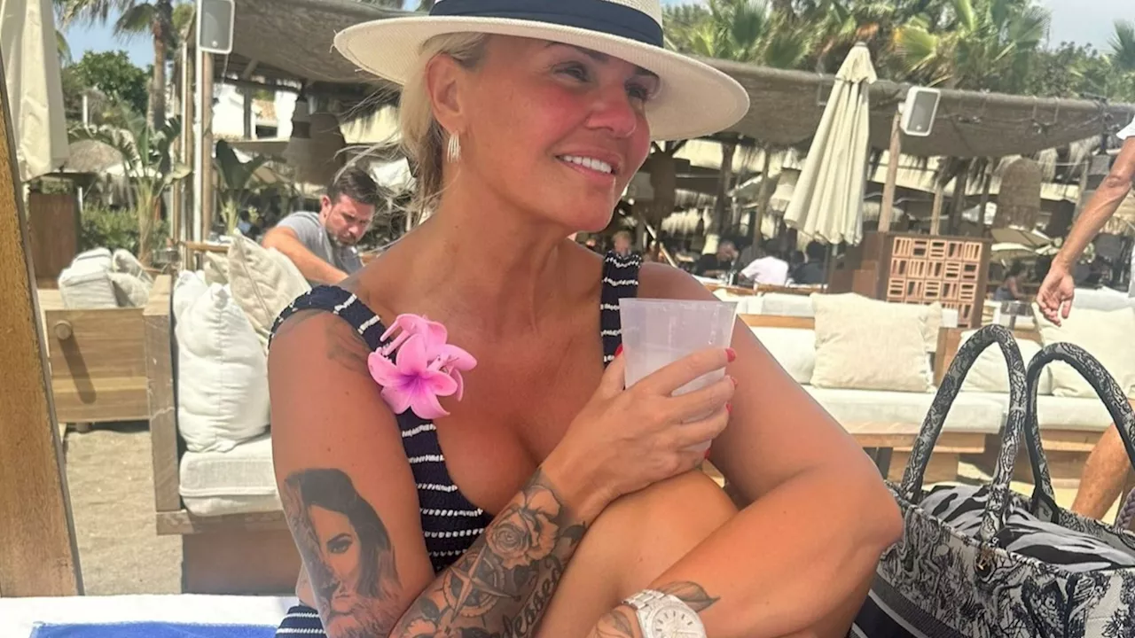 Kerry Katona flashes huge £24k Rolex as she strips off to a bikini to sunbathe on holiday...