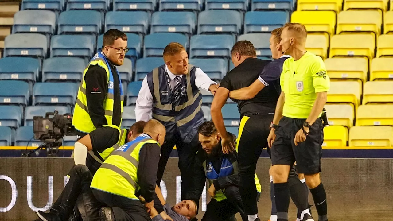 Shocking moment Carabao Cup clash suspended as idiot pitch invader restrained by goalkeeping coach and...