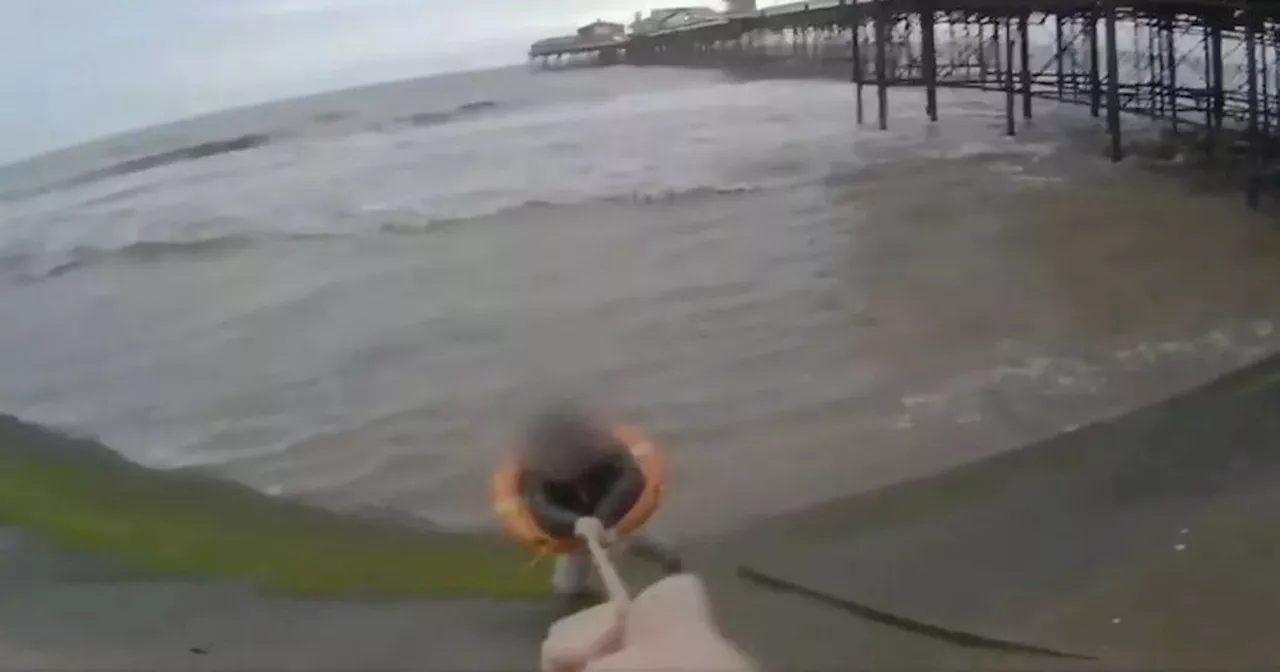 Dramatic moment woman pulled from sea after slipping off wall