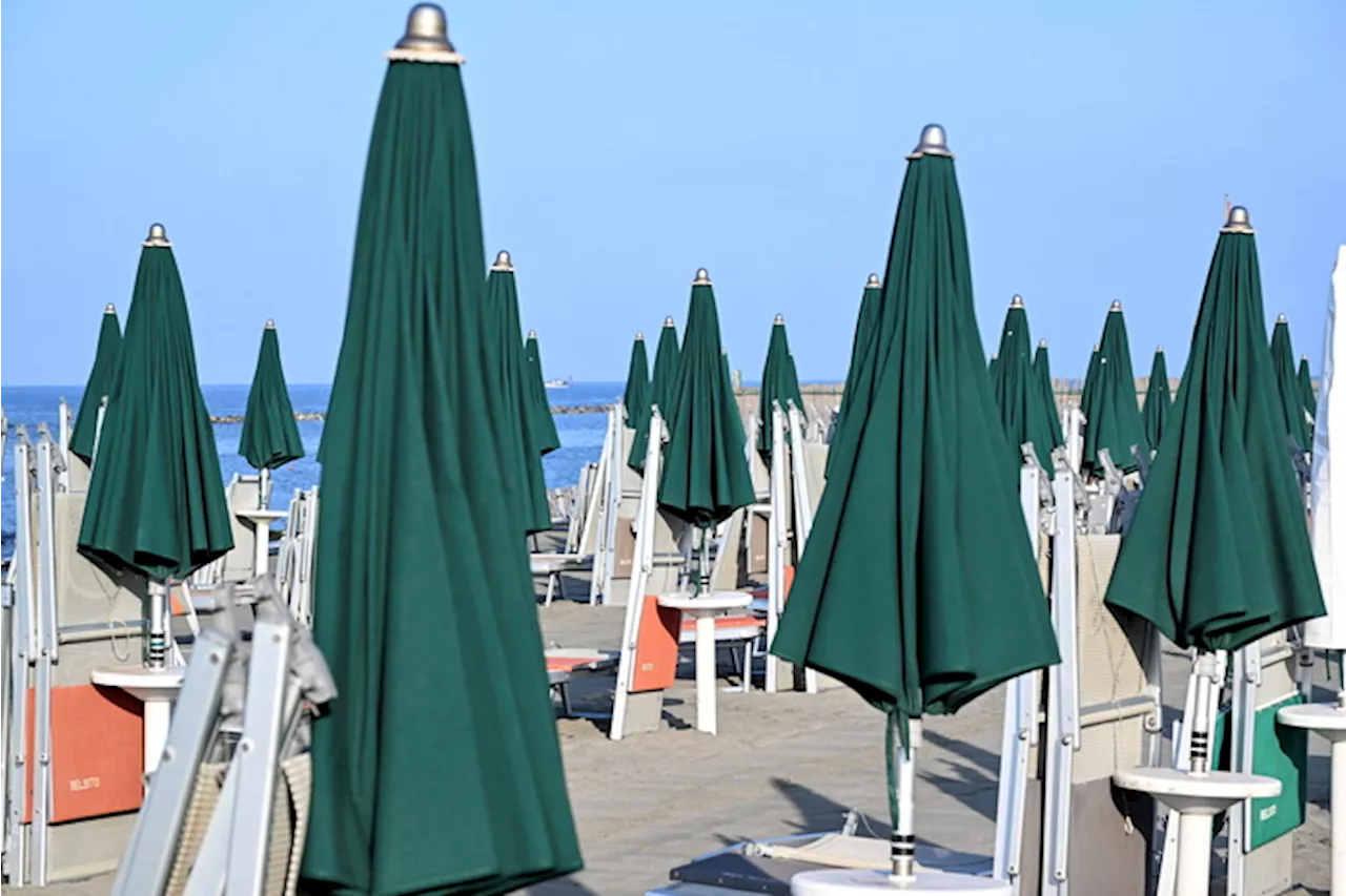 Sedie a sdraio e ombrelloni chiusi sulla spiaggia di Ostia