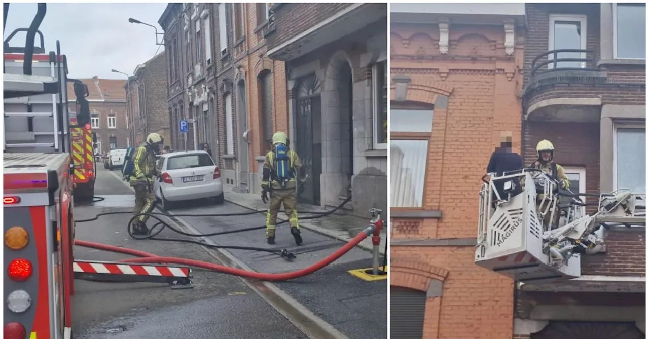 Une dame évacuée par les pompiers lors d’un début d’incendie dans un immeuble à appartements, à Châtelineau