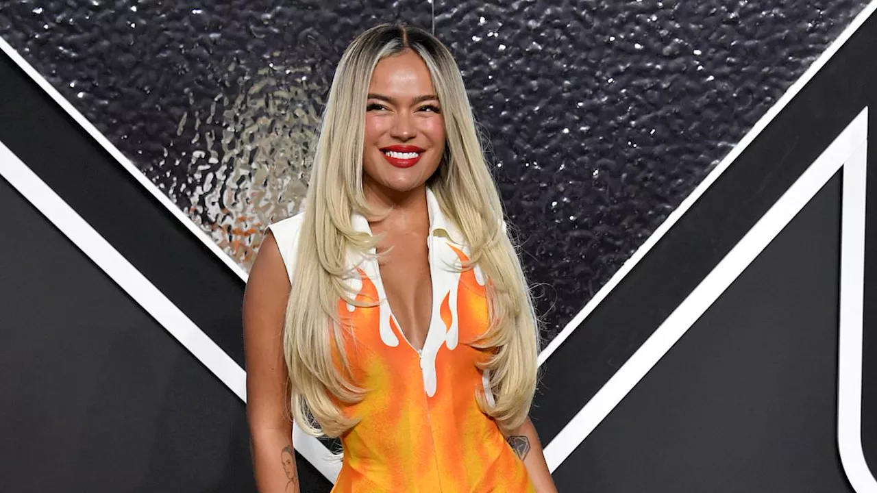 Karol G fires up the red carpet early in a busty flame-inspired dress at the 2024 MTV VMAs in New...