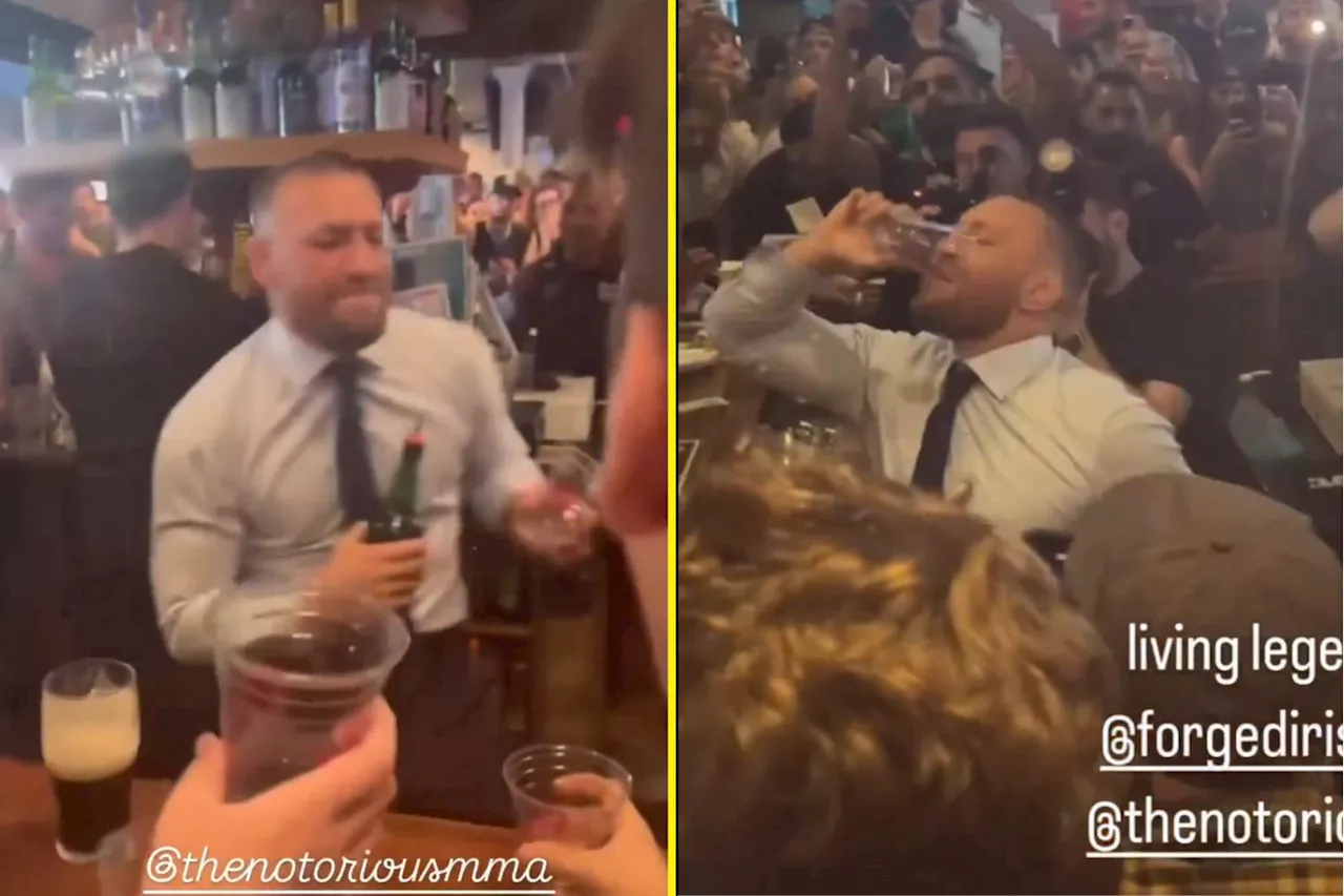 Best-dressed barman Conor McGregor downs drink as he serves thousands of fans his whiskey in New Jersey bar...