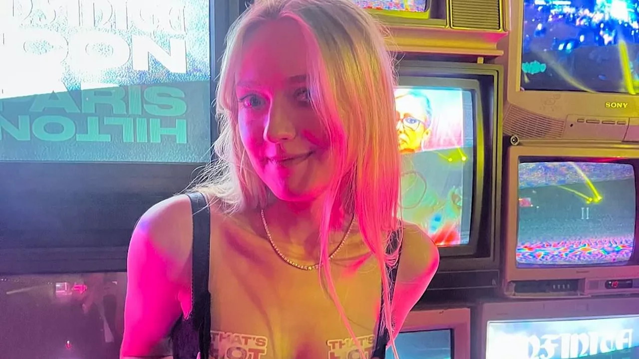 Dakota Fanning shows her support for Paris Hilton's new album with 'that's hot' stickers worn over...