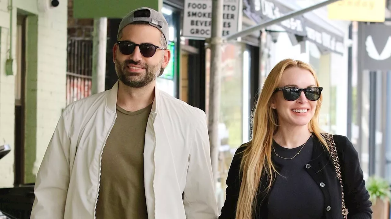 Lindsay Lohan and husband Bader Shammas stroll hand-in-hand after she stunned at Michael Kors...