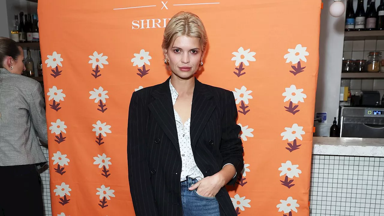 Pixie Geldof cuts an effortlessly chic figure in a black pinstripe blazer and jeans as she leads the...