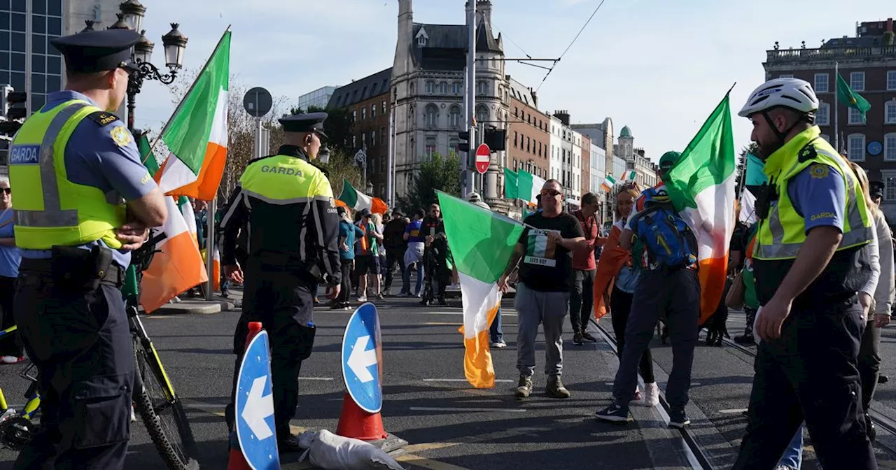 Anti-immigration protestors sit on O'Connell Bridge after Leinster House protest