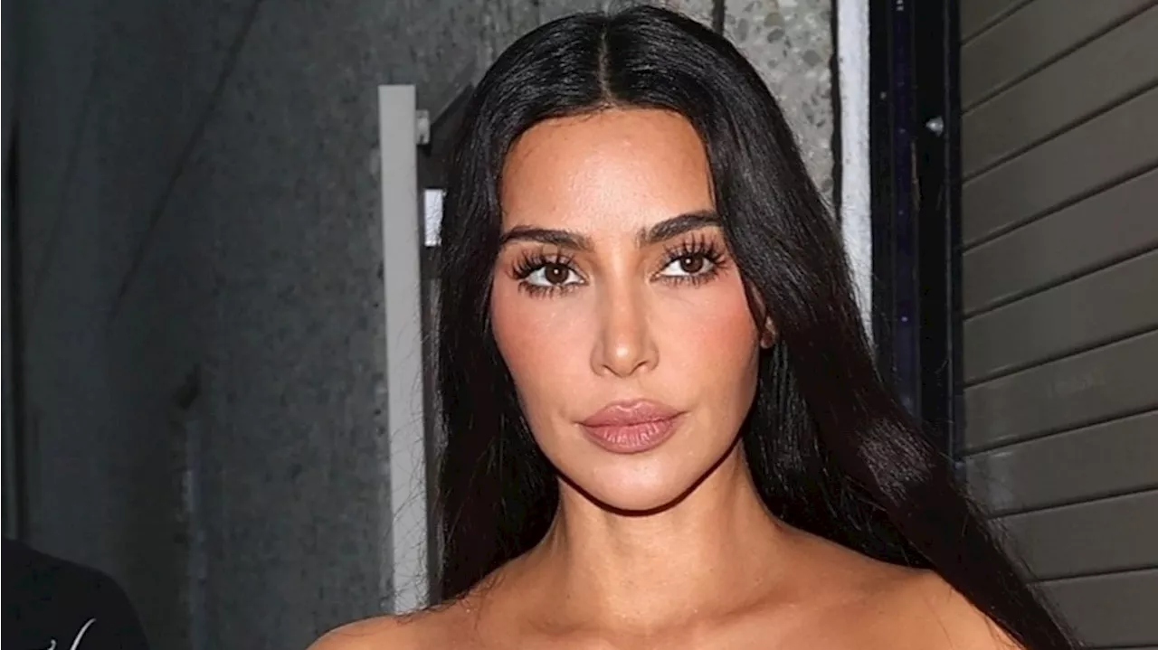 Kim Kardashian looks incredible as she flashes her abs in a tube top as she climbs inside her $100k Tesla...