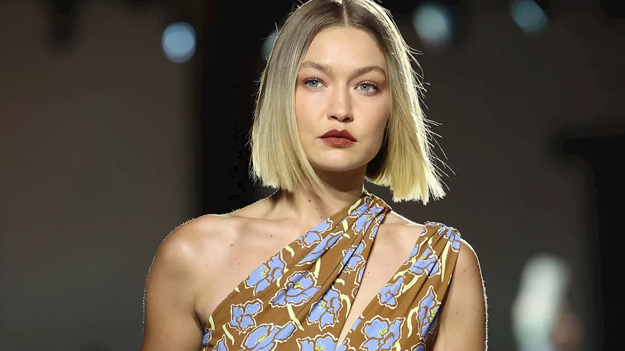 Gigi Hadid storms the Versace runway in an asymmetrical floral dress as she joins Vittoria Ceretti...