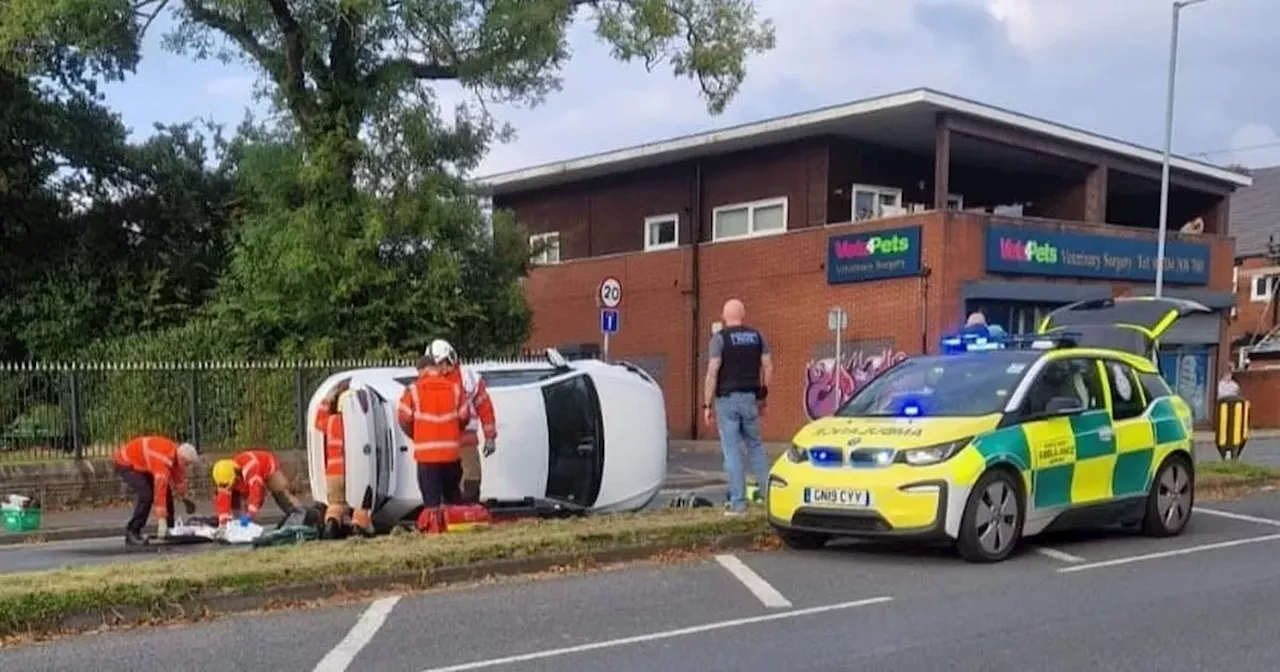 Emergency services descend on major road as car left on side following crash