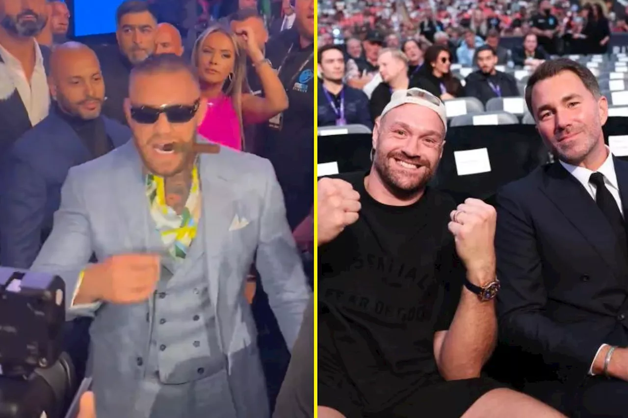 Conor McGregor holds cigar in star-studded ringside seat next to Terence Crawford and Tyson Fury as he...