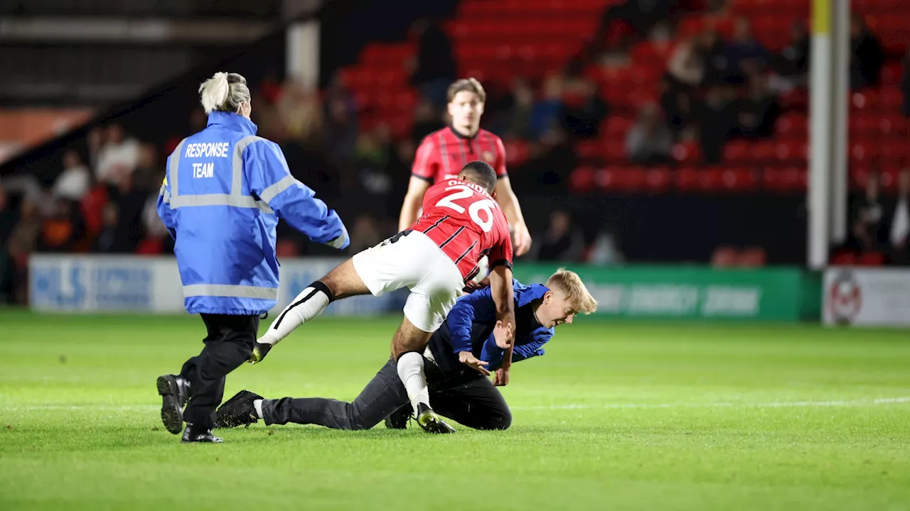 Leicester fan tackled by Walsall player after running onto pitch to berate Steve Cooper during Carabao Cup...