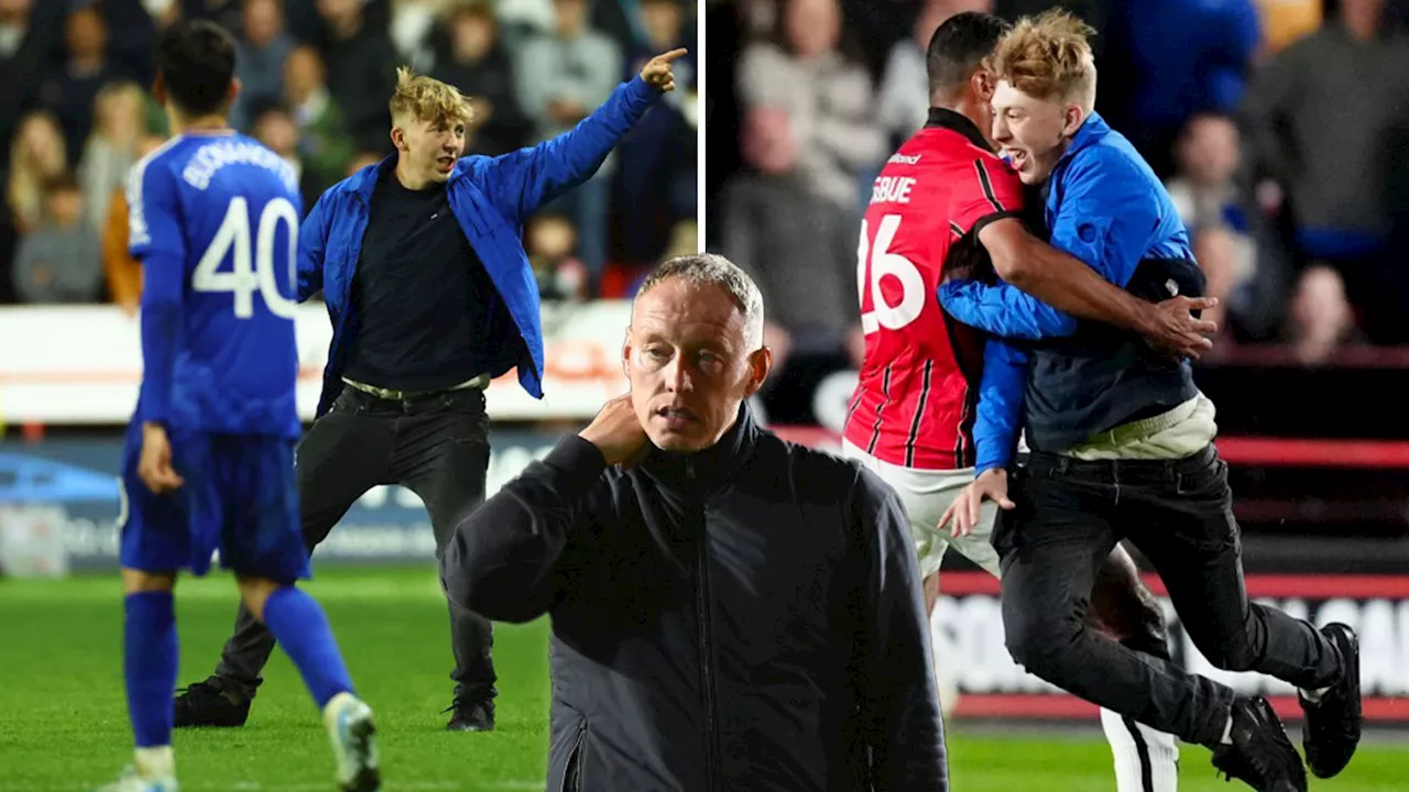 Shocking moment idiot pitch invader stopped from confronting Leicester boss Cooper by being tackled to...